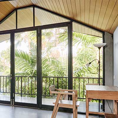 an interior view of a lanai showing the floridafoliage outsdie of the sliding glass window